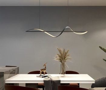 A dining room with a dramatic pendant light and a simple centerpiece.